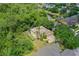 Birds eye view of tan house with green backyard, screened in lanai, surrounded by lush trees and landscaping at 3430 Turningwind Ln, Winter Garden, FL 34787