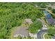 Birds eye view of tan house with green backyard, screened in lanai, surrounded by lush trees and landscaping at 3430 Turningwind Ln, Winter Garden, FL 34787