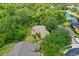 Aerial view of a well-maintained yellow home with a three-car garage, lush landscaping, and a pond view at 3430 Turningwind Ln, Winter Garden, FL 34787