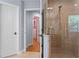Bright bathroom with tile shower and glass doors, plus a glimpse into the spacious walk-in closet at 3430 Turningwind Ln, Winter Garden, FL 34787