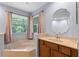 Bathroom featuring a soaking tub, a vanity with sink, and natural light from a window at 3430 Turningwind Ln, Winter Garden, FL 34787