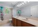 Bathroom featuring a double vanity with large mirror, bathtub, shower with floral shower curtains, and natural lighting at 3430 Turningwind Ln, Winter Garden, FL 34787