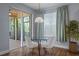 Cozy breakfast nook with glass table and sliders to a screened lanai with wooded view at 3430 Turningwind Ln, Winter Garden, FL 34787