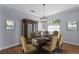Elegant dining room with wood floors, stylish chandelier, and seating for six at 3430 Turningwind Ln, Winter Garden, FL 34787