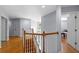 Upstairs hallway with wood floors, staircase, and chandelier at 3430 Turningwind Ln, Winter Garden, FL 34787