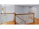 Upstairs landing with wood floors and a decorative railing, offering a view downstairs at 3430 Turningwind Ln, Winter Garden, FL 34787