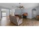 Comfortable living room featuring wood floors, a ceiling fan, and a relaxing recliner at 3430 Turningwind Ln, Winter Garden, FL 34787