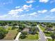 Aerial view of the home in a neighborhood with mature trees and a lake in the background at 39100 Tacoma Dr, Lady Lake, FL 32159
