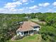 Aerial view of the home with screened lanai surrounded by mature trees and landscaping at 39100 Tacoma Dr, Lady Lake, FL 32159