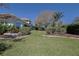 Manicured backyard featuring lawn, mature shrubs, and flower beds at 39100 Tacoma Dr, Lady Lake, FL 32159