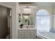 Bathroom showcasing the vanity with a large mirror, soaking tub, and a separate water closet at 39100 Tacoma Dr, Lady Lake, FL 32159