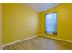 Cozy bedroom featuring wood flooring, bright yellow walls and a window with sheer curtains at 39100 Tacoma Dr, Lady Lake, FL 32159