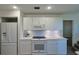 Bright kitchen featuring white appliances, subway tile backsplash, and ample cabinet space at 39100 Tacoma Dr, Lady Lake, FL 32159
