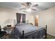 Standard bedroom featuring a metal bed frame, ceiling fan, and a window with curtains at 40619 W 3Rd Ave, Umatilla, FL 32784