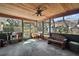Screened porch featuring wood ceiling, concrete floors, with a bench, table, and views of the backyard at 40619 W 3Rd Ave, Umatilla, FL 32784