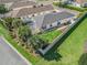 Aerial view of the home's backyard with screened lanai, manicured lawn, landscaping, and privacy fence at 409 Valverda Dr, The Villages, FL 32162