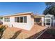 Rear exterior view of the house featuring patio, manicured landscaping, and lawn at 427 Cambio Ct, The Villages, FL 32159