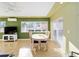 Sunny dining room with green accent wall, modern lighting, and access to outdoor views, perfect for entertaining at 427 Cambio Ct, The Villages, FL 32159