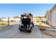 Rear view of a silver golf cart with black seats parked on a concrete driveway in a residential neighborhood at 427 Cambio Ct, The Villages, FL 32159