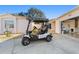Eye-level view of golf cart in front of the garage of home number 427 at 427 Cambio Ct, The Villages, FL 32159