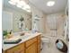 Charming bathroom featuring wood cabinets, decorative mirror, and tub shower combo at 447 Simpson St, The Villages, FL 32162
