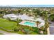 Scenic aerial view of the community pool and clubhouse nestled among palm trees and lush landscaping at 447 Simpson St, The Villages, FL 32162