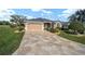 Charming single-story home with a beautiful stamped concrete driveway and manicured lawn at 447 Simpson St, The Villages, FL 32162