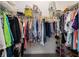 Well organized walk-in closet with clothing hung on rods and storage for shoes and boxes at 447 Simpson St, The Villages, FL 32162