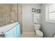 This renovated water closet has a shower with glass door, toilet, and shutters on the window at 447 Simpson St, The Villages, FL 32162