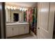 Bathroom featuring double sink vanity with neutral countertops and a Hogwarts themed shower curtain at 4836 Romeo Cir, Kissimmee, FL 34746