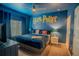 Whimsical bedroom with blue walls, stylish fan, and a large Harry Potter themed wall graphic at 4836 Romeo Cir, Kissimmee, FL 34746