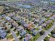 Neighborhood aerial view with single-story home with well-manicured lawn with other homes, streets, and lakes nearby at 485 Pixie Ln, The Villages, FL 32162