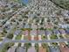 Neighborhood aerial view with single-story home with well-manicured lawn with other homes, streets, a pond, and a golf course nearby at 485 Pixie Ln, The Villages, FL 32162