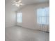 Bright bedroom featuring white walls, light-colored floors, and two windows with sheer curtains at 485 Pixie Ln, The Villages, FL 32162