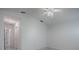 Bright bedroom with white walls and ceiling fan leading to an open doorway at 485 Pixie Ln, The Villages, FL 32162