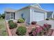 Well-maintained home exterior with a garage, screened patio, and manicured landscaping at 485 Pixie Ln, The Villages, FL 32162