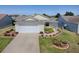 Charming single-story home featuring a well-manicured lawn, inviting curb appeal, and an attached two-car garage at 485 Pixie Ln, The Villages, FL 32162