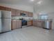 Kitchen featuring stainless steel appliances, wood cabinets, and neutral walls at 485 Pixie Ln, The Villages, FL 32162
