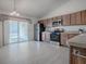 Bright kitchen features stainless steel appliances and sliding glass doors to the lanai at 485 Pixie Ln, The Villages, FL 32162