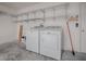 Well-lit laundry room featuring a washer, dryer, and storage shelves at 485 Pixie Ln, The Villages, FL 32162