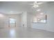 Spacious living room with a view of the kitchen, featuring white walls and modern flooring at 485 Pixie Ln, The Villages, FL 32162