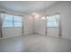 Bright living room featuring white walls, large windows, and a modern chandelier at 485 Pixie Ln, The Villages, FL 32162