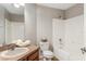 Bright bathroom with a shower-tub combo, white toilet, and a brown vanity with a sink at 519 Hearthglen Blvd, Winter Garden, FL 34787
