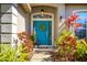 Inviting front entrance with a vibrant blue door, decorative wreath, colorful plants and a welcome sign at 519 Hearthglen Blvd, Winter Garden, FL 34787