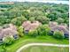 Aerial view of villas surrounded by verdant landscaping and a golf course, offering a tranquil and luxurious living experience at 54 Camino Real Blvd # 504, Howey In The Hills, FL 34737
