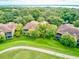 Aerial view of villas surrounded by lush landscaping and a golf course, offering a serene and luxurious living environment at 54 Camino Real Blvd # 504, Howey In The Hills, FL 34737