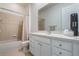 Bathroom features shower/tub combo, white cabinets, and neutral tile at 54 Camino Real Blvd # 504, Howey In The Hills, FL 34737