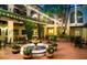 Charming courtyard with a central fountain, lush greenery, string lights, and inviting seating, perfect for relaxation and gatherings at 54 Camino Real Blvd # 504, Howey In The Hills, FL 34737