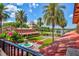 Beautiful exterior view features a fountain, a lush garden, a tile roof and palm trees in a resort-style setting at 54 Camino Real Blvd # 504, Howey In The Hills, FL 34737