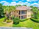 Exterior view of a two-story villa boasting a screened-in balcony and mature landscaping at 54 Camino Real Blvd # 504, Howey In The Hills, FL 34737
